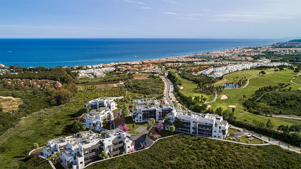 Una vista aérea de la urbanización, mostrando su ubicación privilegiada entre el campo de golf y el mar.