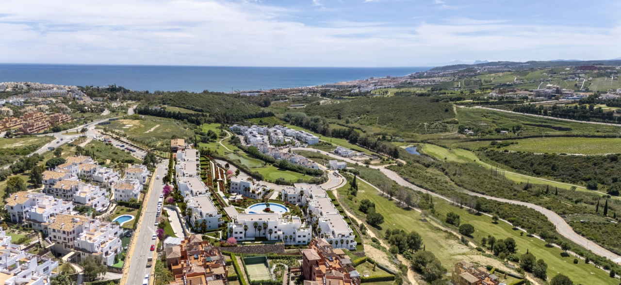 Una inspiradora vista aérea de la urbanización, mostrando su integración con el campo de golf y el cercano mar Mediterráneo.