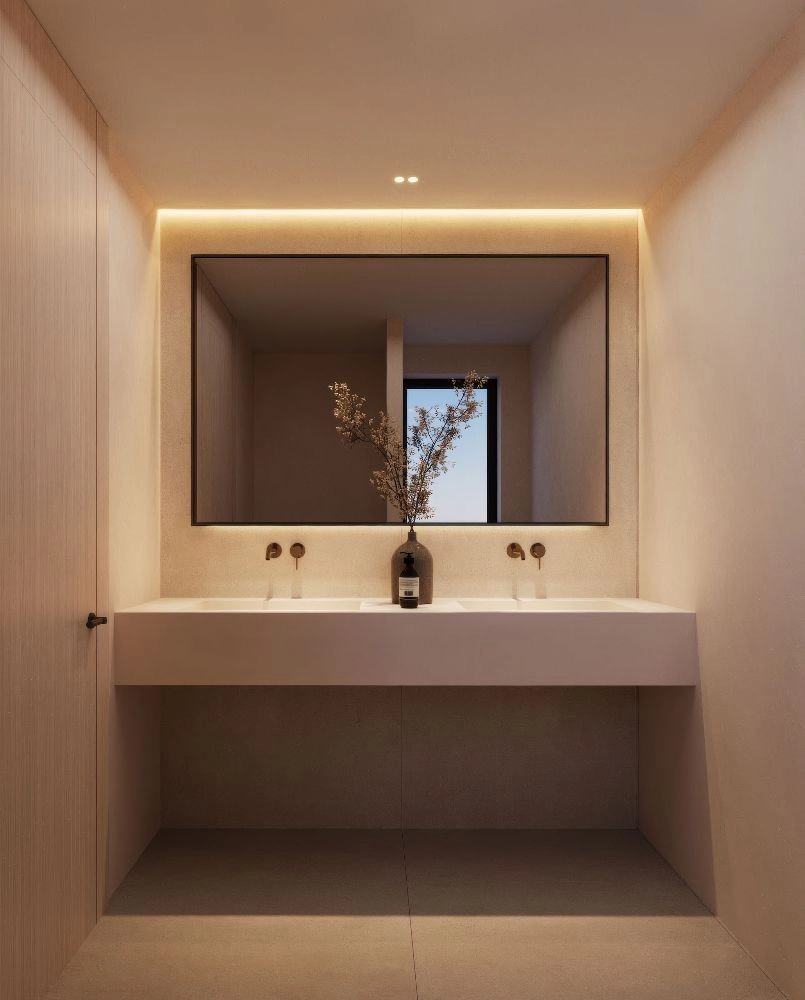 Un baño moderno de líneas limpias, doble lavabo y elegante iluminación trasera, creando un ambiente de spa.