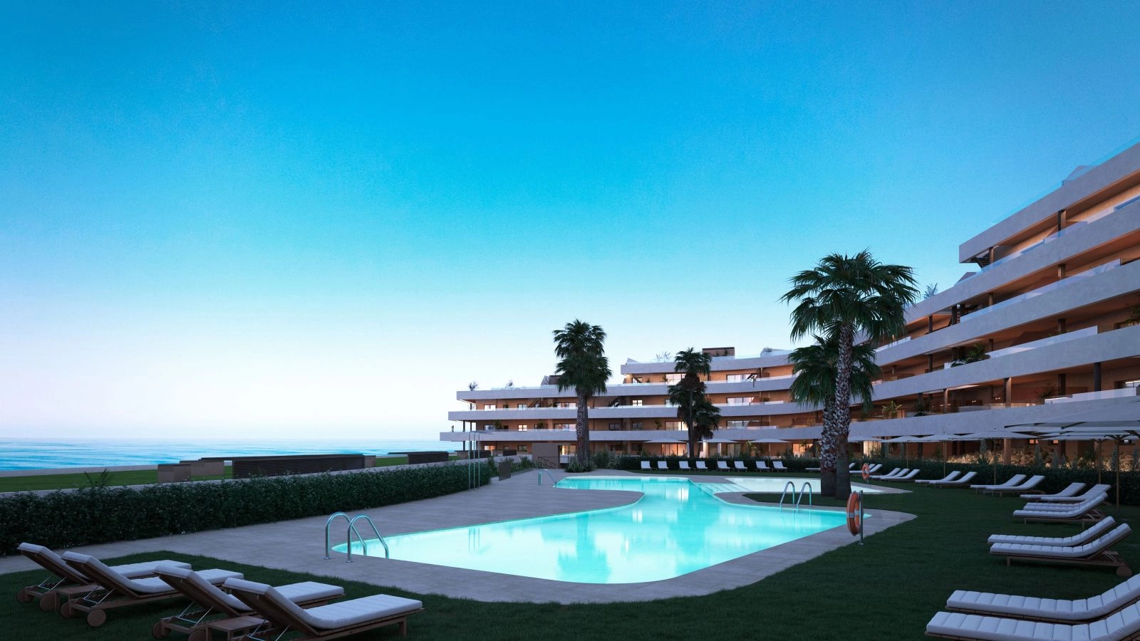 La atractiva zona de piscina comunitaria, bellamente iluminada al caer la noche.