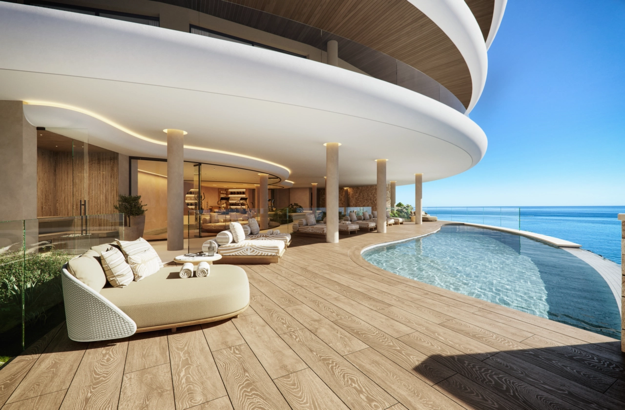 La elegante zona de la piscina infinita comunitaria, un oasis perfecto para relajarse mientras disfruta de las infinitas vistas al mar.