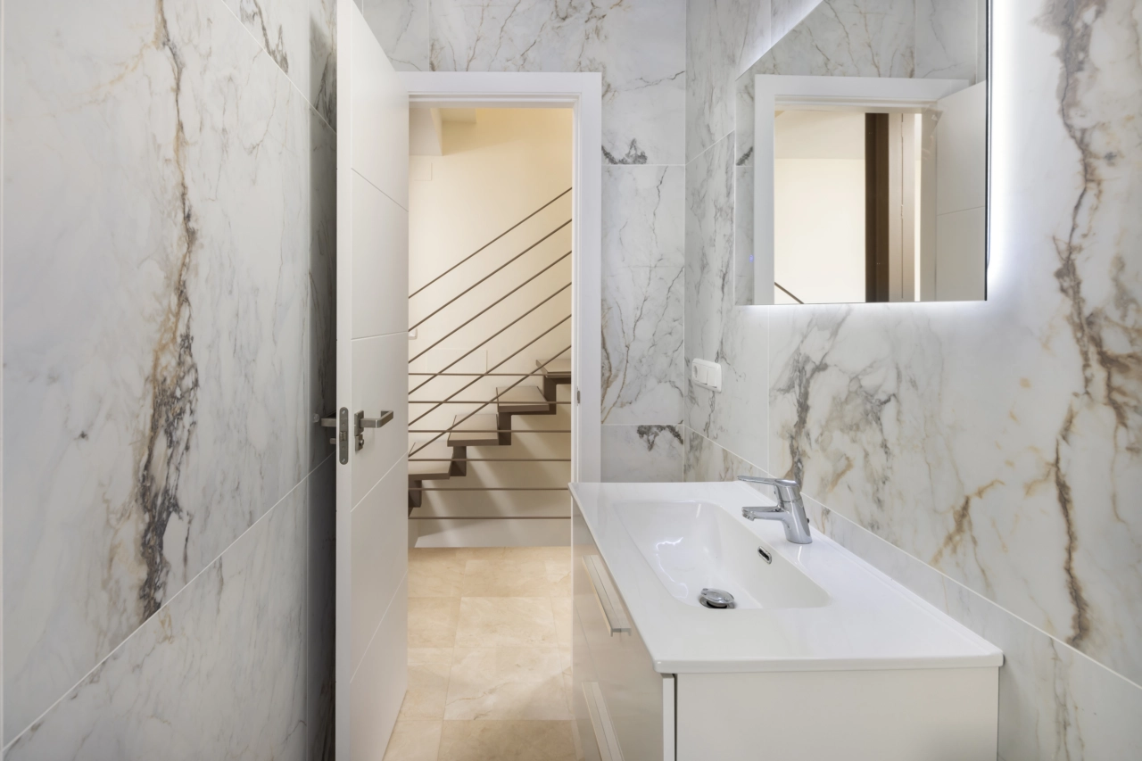 Un moderno baño de invitados con elegantes azulejos y accesorios de calidad.