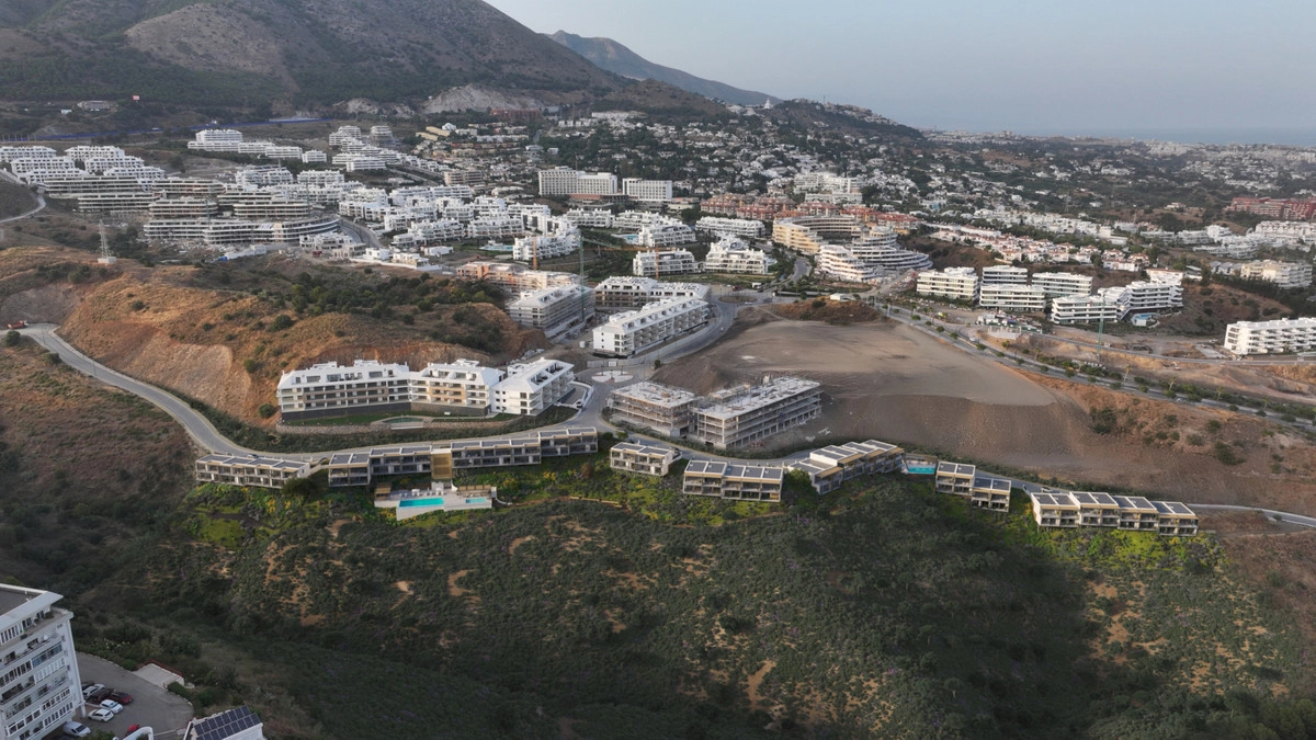 Vista aérea que muestra la ubicación privilegiada de la urbanización entre las montañas y el mar.