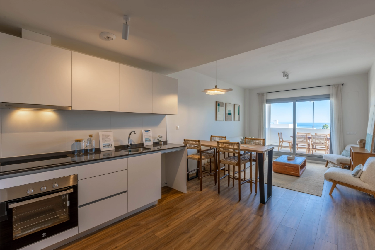 Una cocina moderna y totalmente equipada se abre a la sala de estar, creando un corazón luminoso y sociable para el hogar.