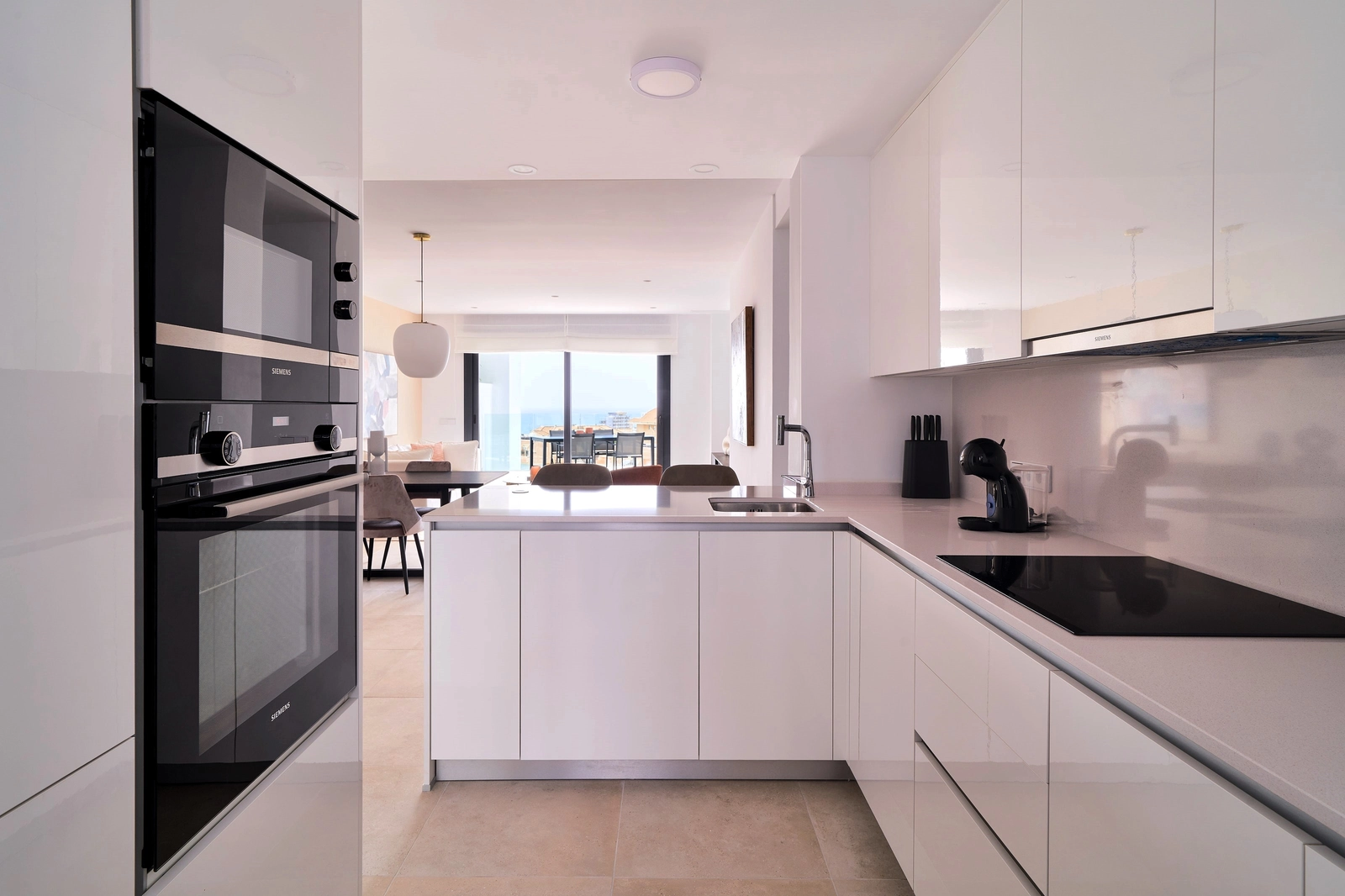 Una cocina moderna y totalmente equipada con barra de desayuno, diseñada para la funcionalidad y el estilo, que se integra en la zona de salón.