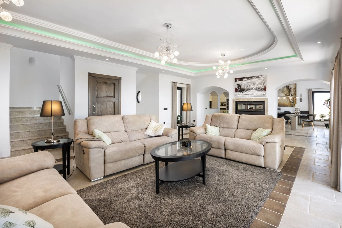 El elegante y espacioso salón, lleno de luz natural, está diseñado para el confort y la relajación.