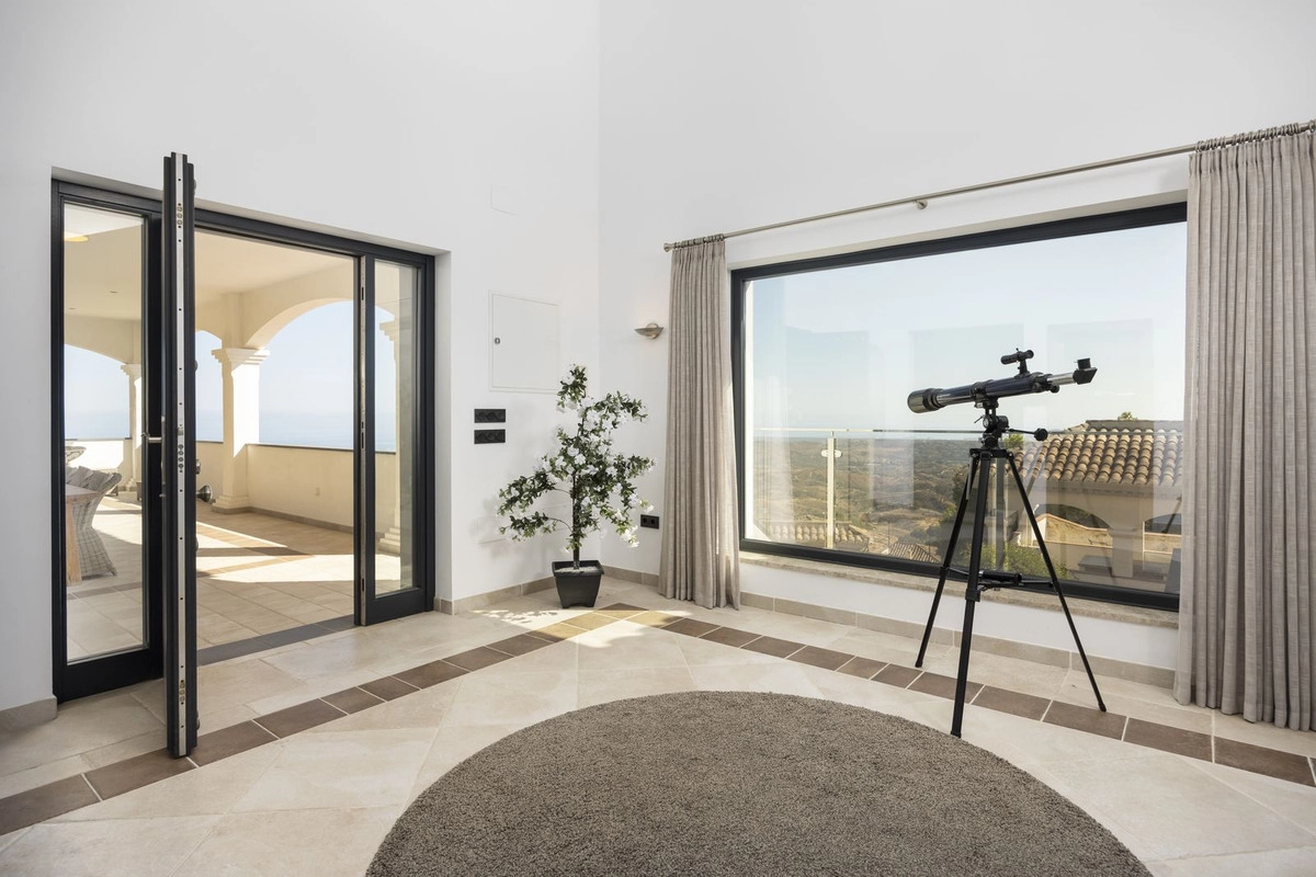 Un rincón tranquilo del hogar donde grandes ventanales enmarcan el espectacular paisaje y las puertas se abren a la terraza.