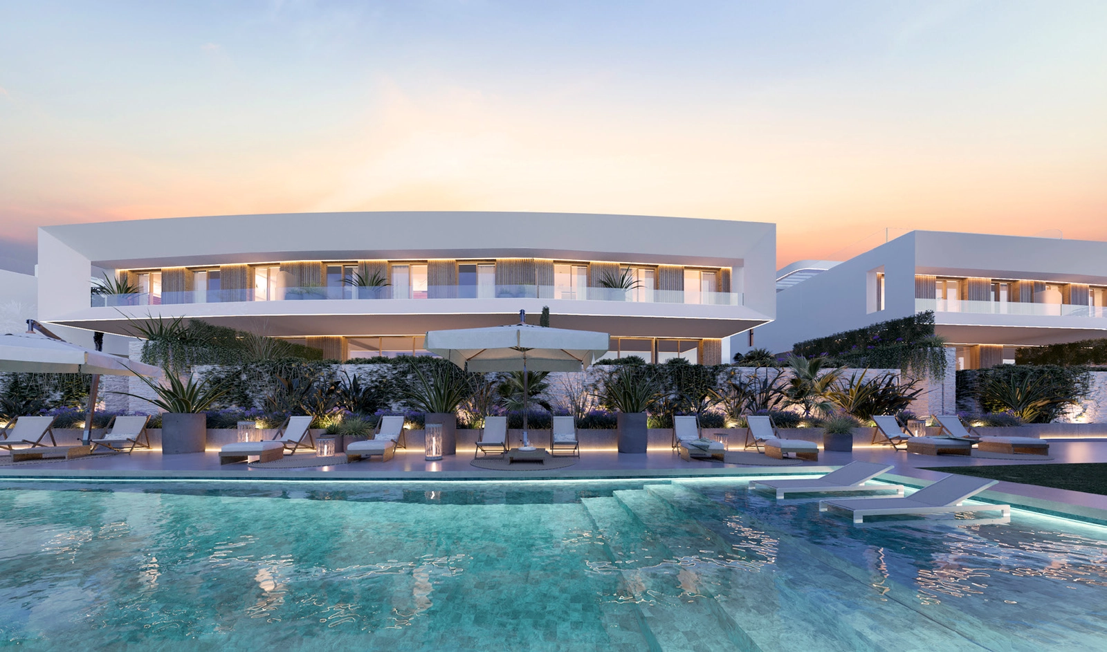 La elegante zona de piscina comunitaria, bellamente iluminada para la relajación nocturna.