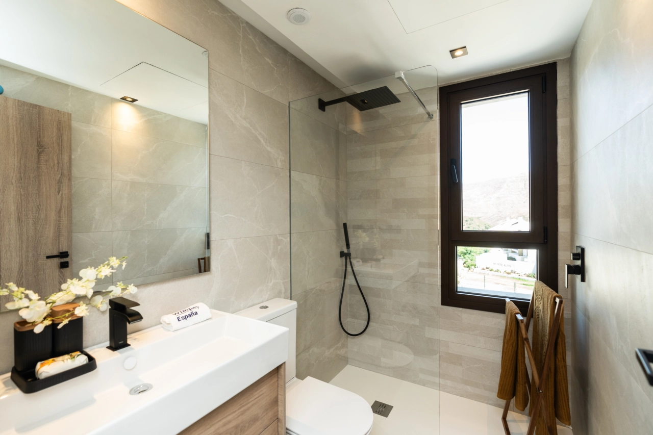 Un baño elegante y moderno con accesorios de alta calidad y ducha a ras de suelo.