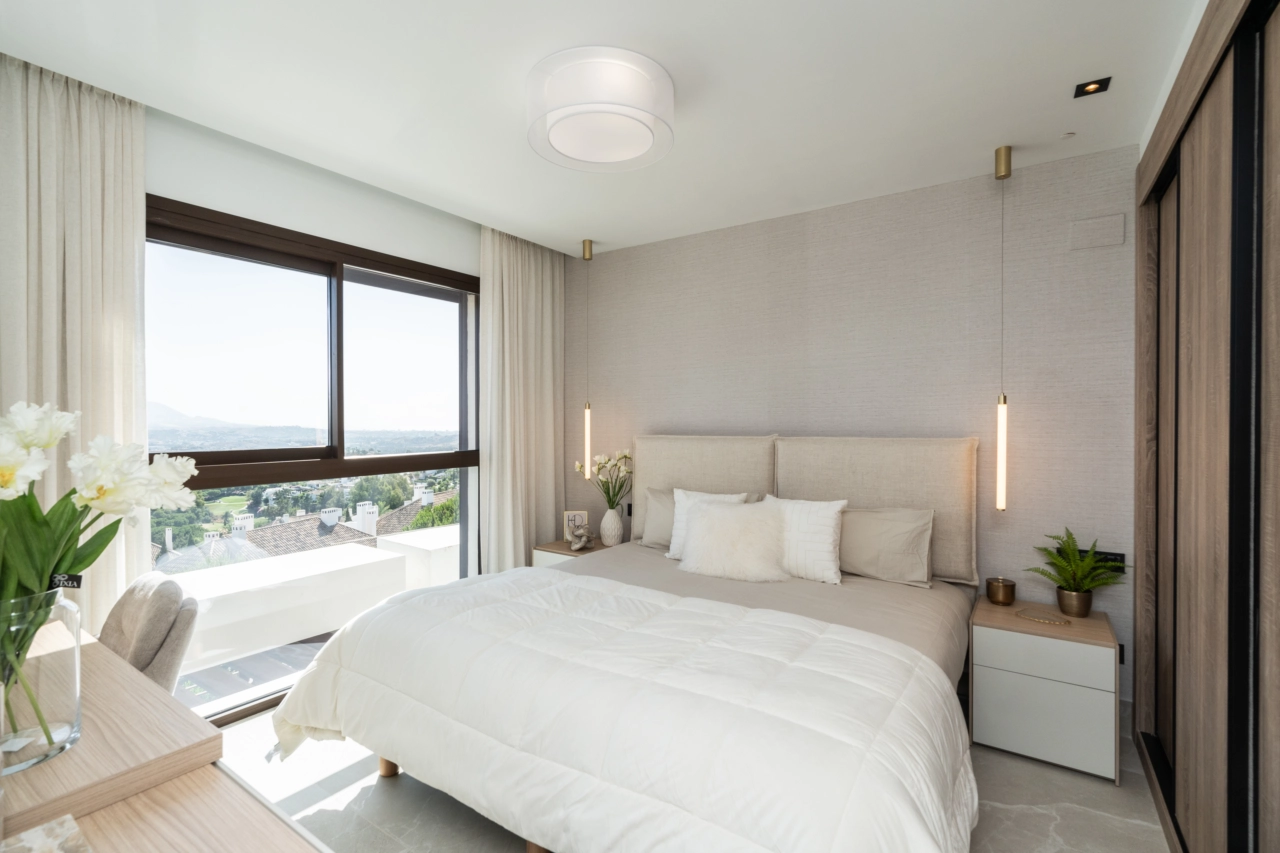 El dormitorio principal es un refugio tranquilo con grandes ventanales que enmarcan el hermoso paisaje.