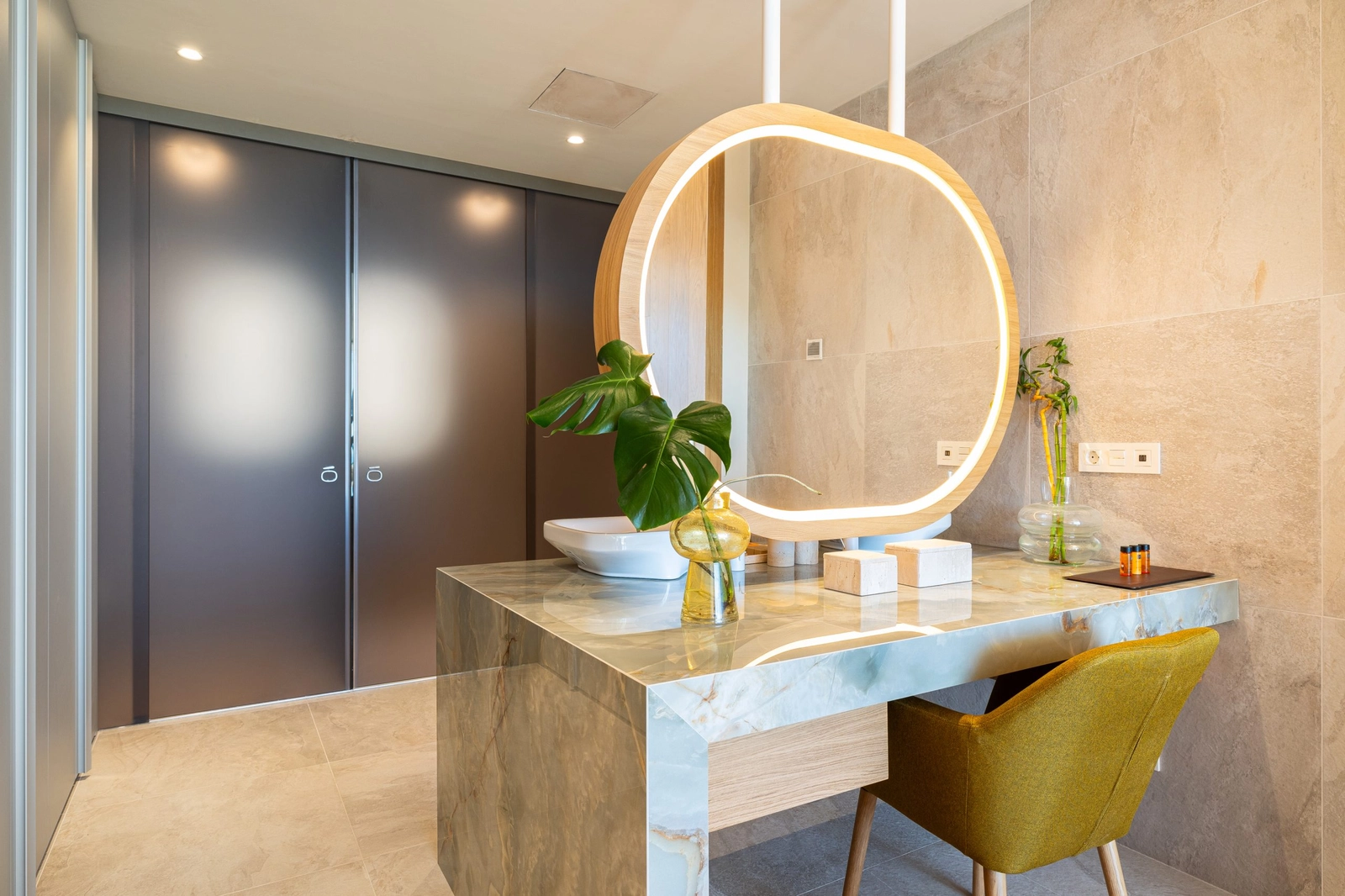 Un elegante mueble de lavabo, elaborado con un hermoso mármol verde y accesorios de diseño.