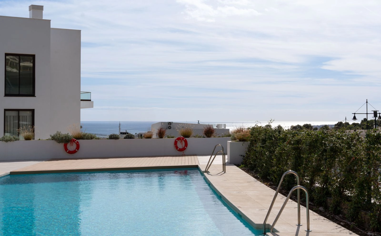 Disfrute de la gran piscina comunitaria con preciosas vistas al mar, rodeada de jardines paisajísticos.