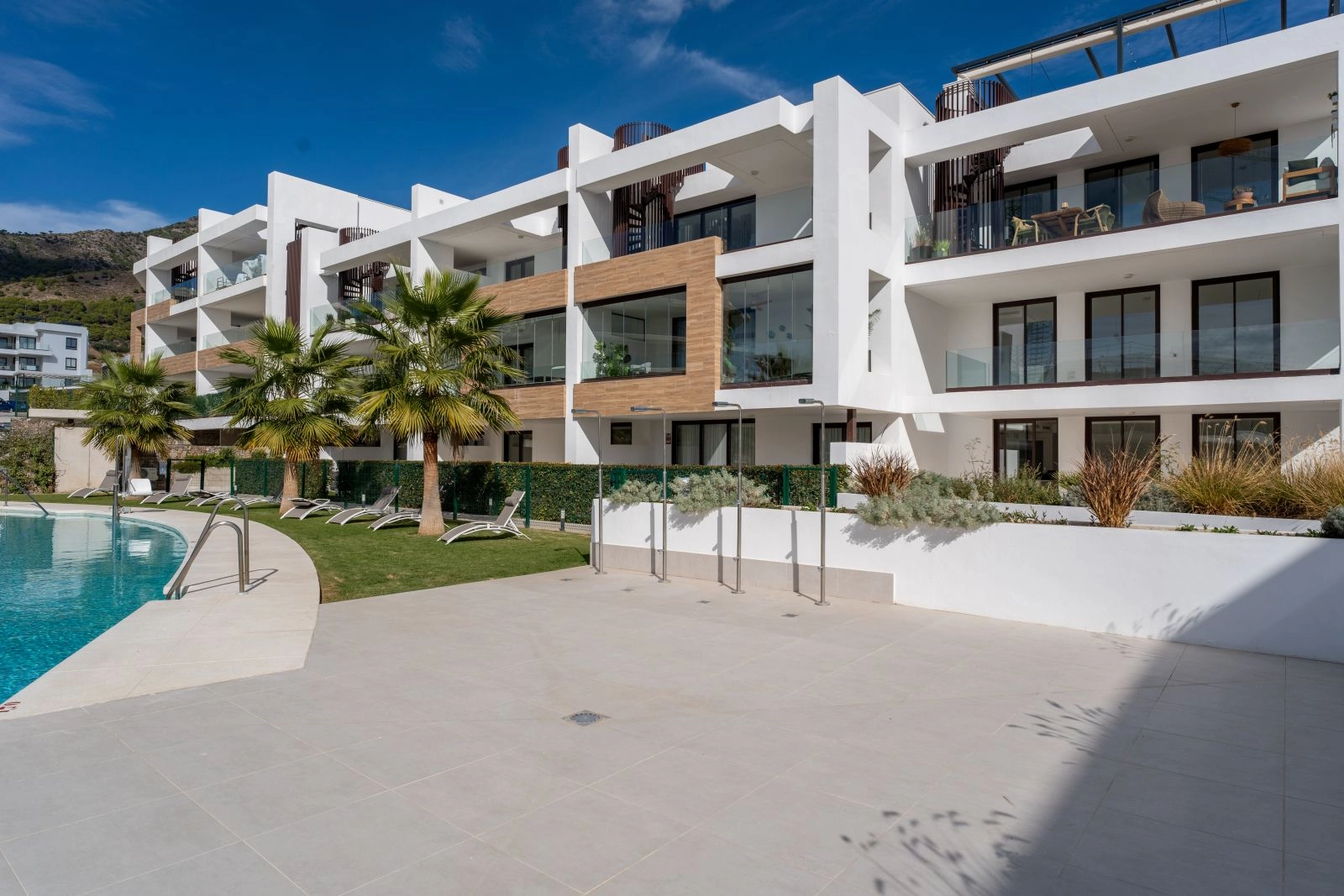 La arquitectura moderna de la promoción se integra a la perfección con el exuberante entorno verde.