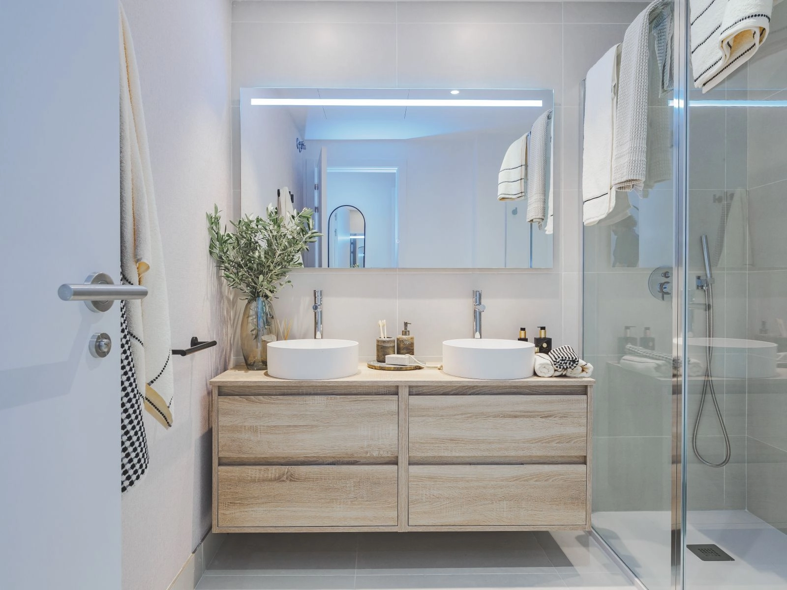 El baño principal presenta un diseño contemporáneo con un doble lavabo y accesorios de alta calidad.