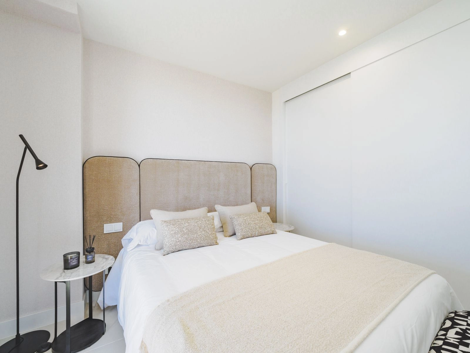 Un cómodo dormitorio de invitados con líneas limpias, tonos neutros y armarios empotrados.