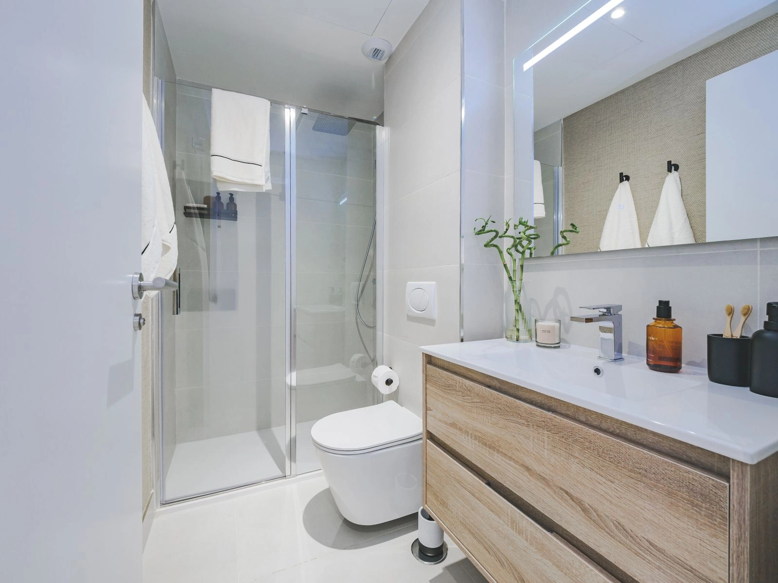 Un segundo baño que muestra estilo y funcionalidad modernos con una amplia ducha a ras de suelo.