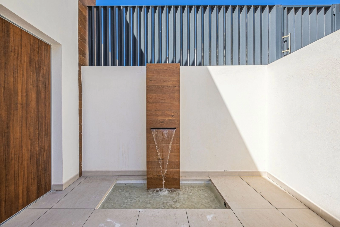 Una tranquila fuente de estilo zen le da la bienvenida en la entrada, creando una sensación de paz y llegada.