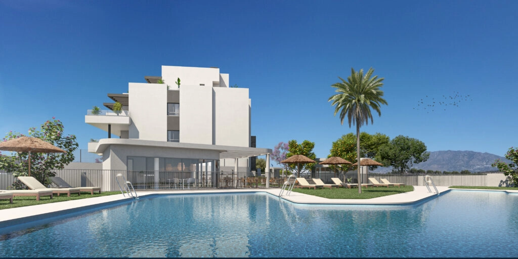 La gran piscina comunitaria está rodeada de relajantes zonas para tomar el sol y hermosos jardines.