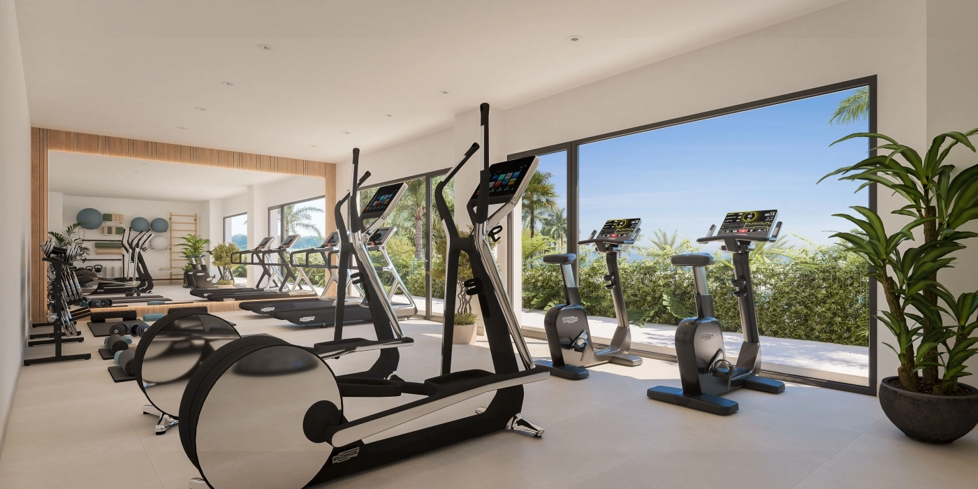 Un gimnasio de última generación con equipamiento moderno y vistas a los jardines.