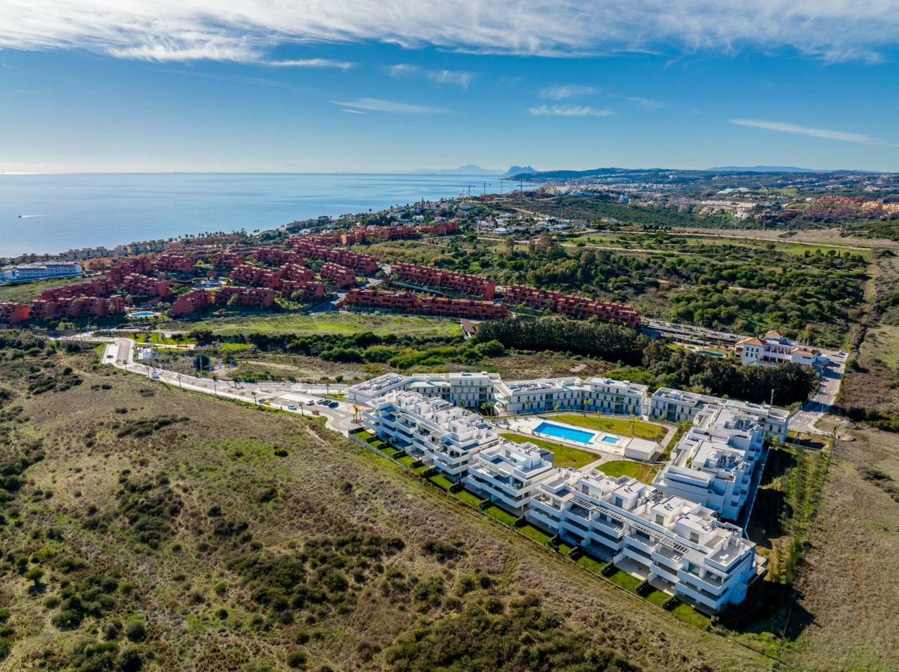 Una vista aérea de Serenity Gardens, mostrando su hermoso entorno en la Costa del Sol, con el mar Mediterráneo cerca.
