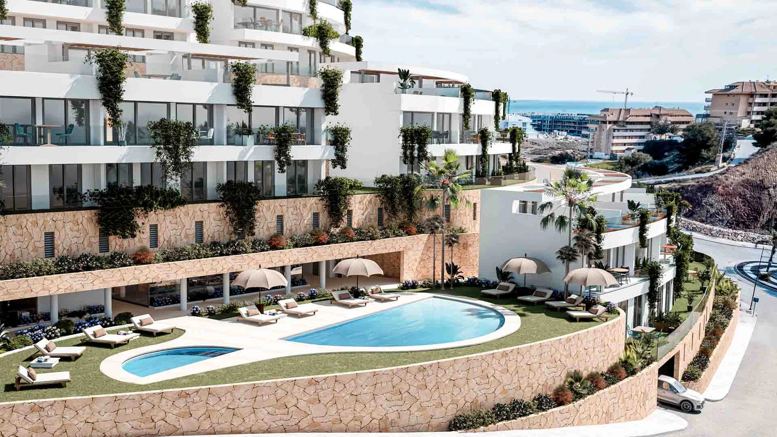 La elegante zona de piscina comunitaria, rodeada de piedra natural y exuberante paisajismo.