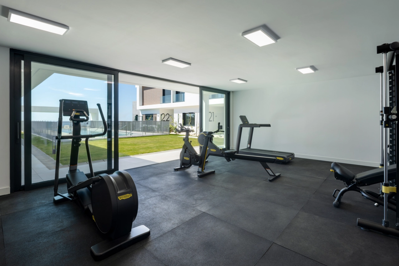 El gimnasio para residentes está totalmente equipado con modernas máquinas de fitness y ofrece inspiradoras vistas al jardín.